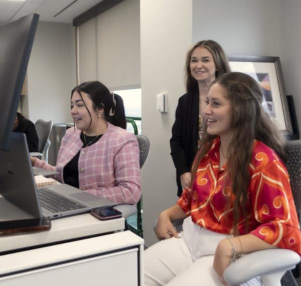 Close up of three interns collaborating at a desk